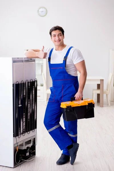 Repairman contractor repairing fridge in DIY concept