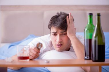Yatakta içen alkolik adam depresyona giriyor.