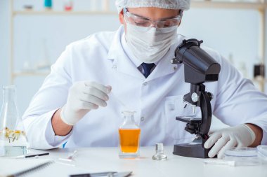 Laboratuvarda parfüm karıştıran bir kimyager.