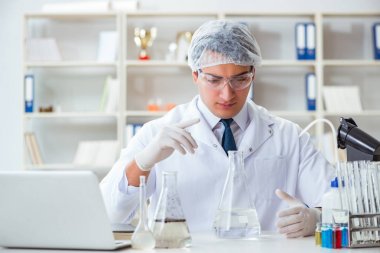 Genç araştırmacı bilim adamı bir su testi kirliliği araştırması yapıyor.