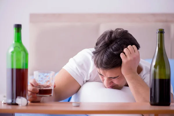 Man alkoholhaltiga drycker i sängen går igenom bryta upp depression — Stockfoto