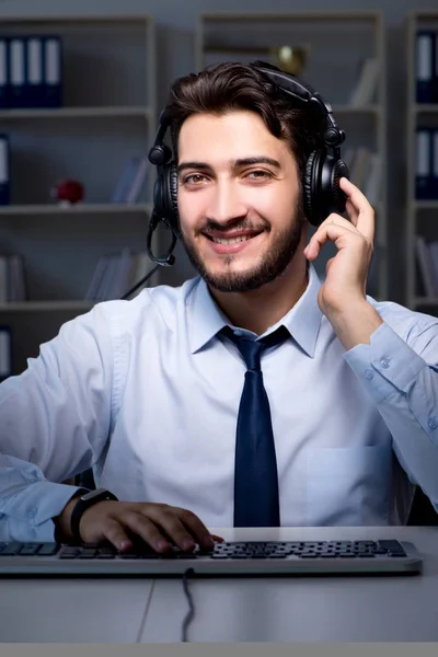 Ung man i call center koncept som arbetar sent övertid på kontoret — Stockfoto