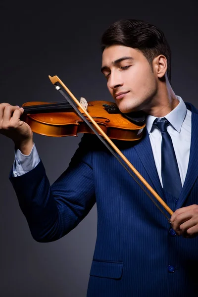 Jovem tocando violino no quarto escuro — Fotografia de Stock