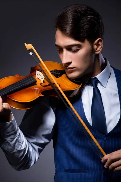 Jovem tocando violino no quarto escuro — Fotografia de Stock