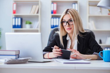 Ofisteki masada dizüstü bilgisayarda çalışan iş kadını.
