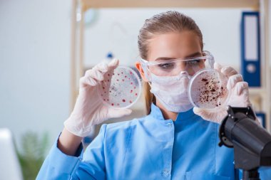 Bir laboratuarda deney yapan kadın bir bilim adamı.