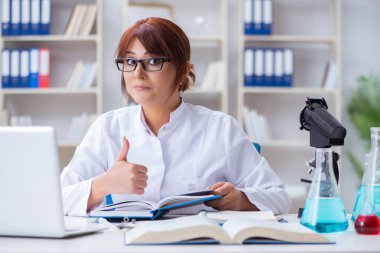 Bir laboratuarda deney yapan kadın bir bilim adamı.