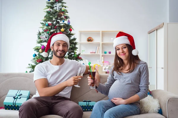 Genç aile Noel 'i kutlayan bir bebek bekliyor.