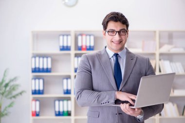 Ofisteki iş adamı dizüstü bilgisayarla çalışıyor.