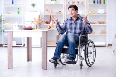 Engelli genç koca mutfakta çalışıyor.