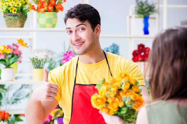 Çiçekçi dükkanında çiçek satıyor.