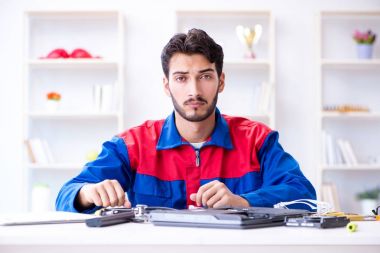 Bilgisayar dizüstü bilgisayarının tamirinde çalışan tamirci.