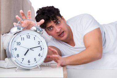 Yatakta uykusuzluk çeken bir adam.