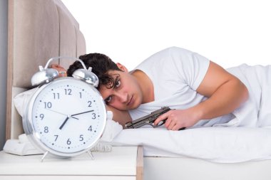 Yatakta uykusuzluk çeken bir adam.