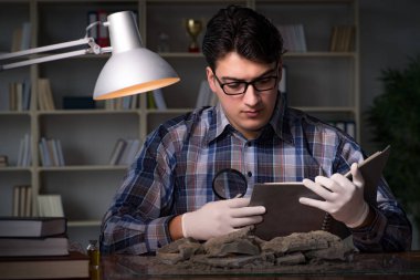 Arkeolog geç saatlere kadar ofiste çalışıyor.