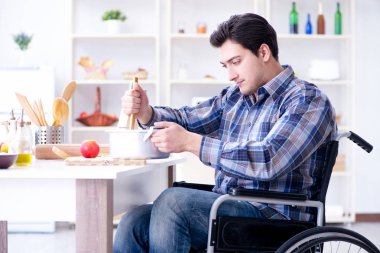 Engelli adam mutfakta çorba hazırlıyor.