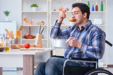 Engelli adam mutfakta çorba hazırlıyor.
