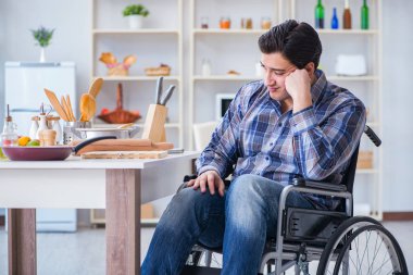 Engelli genç koca mutfakta çalışıyor.