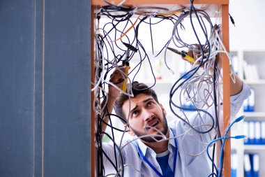Elektrik teknisyeni tamir konseptinde kabloları çözmeye çalışıyor.