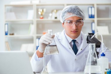 Genç araştırmacı bilim adamı bir su testi kirliliği araştırması yapıyor.