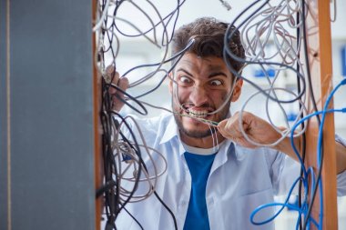 Elektrik teknisyeni tamir konseptinde kabloları çözmeye çalışıyor.