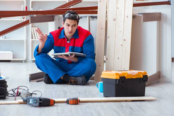 İnşaatta defter planlama yapan genç bir marangoz.