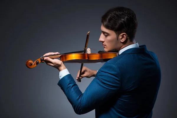 Jovem tocando violino no quarto escuro — Fotografia de Stock