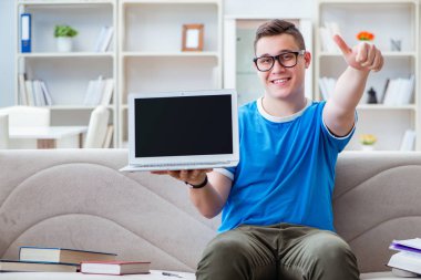 Sınavlara hazırlanan genç öğrenci kanepede ders çalışıyor.