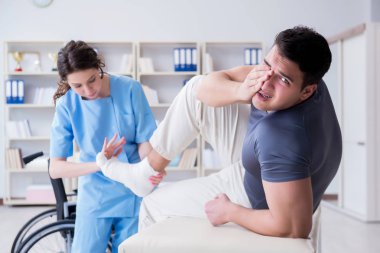 Hastanede yaralanma kontrolü sırasında doktor ve hasta.