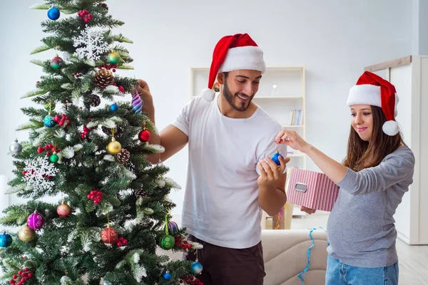 クリスマスを祝う子供の赤ちゃんを期待している若い家族 — ストック写真