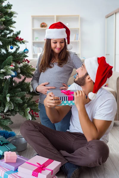 Jeune famille attend bébé célébrant Noël — Photo