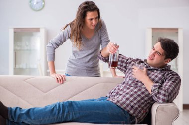Genç bir aile kavramında içki sorunu yaşayan sarhoş bir koca.