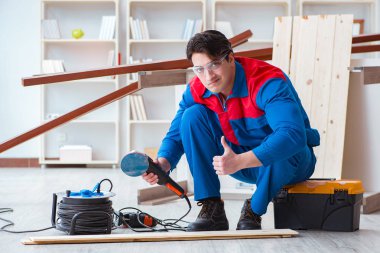 Genç marangoz ahşap kalaslarla çalışıyor.