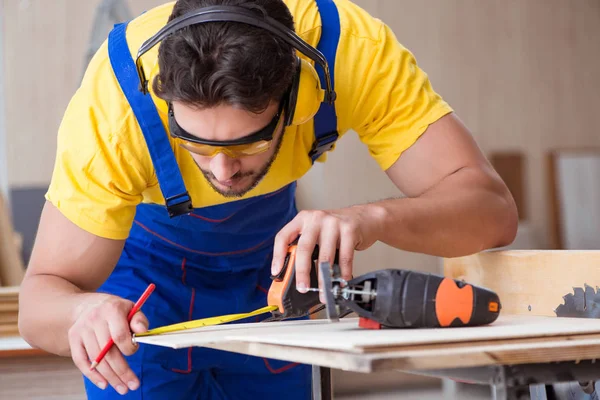 Jonge reparateur timmerman die hout snijdt op cirkelzaag — Stockfoto