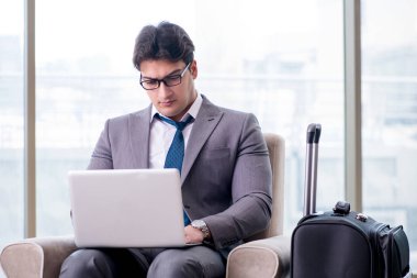 Havaalanındaki iş yerinde genç işadamı uçuş için bekliyor.