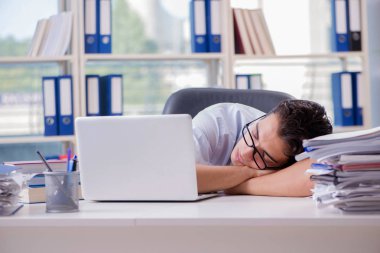 Yorgun iş adamı ofiste oturuyor.