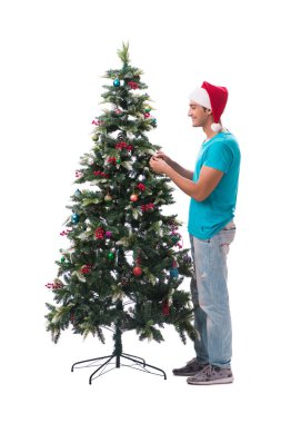 Genç adam beyaz üzerine izole edilmiş noel ağacını süslüyor.