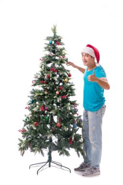 Genç adam beyaz üzerine izole edilmiş noel ağacını süslüyor.