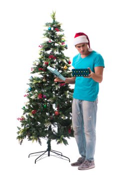 Genç adam beyaz üzerine izole edilmiş noel ağacını süslüyor.