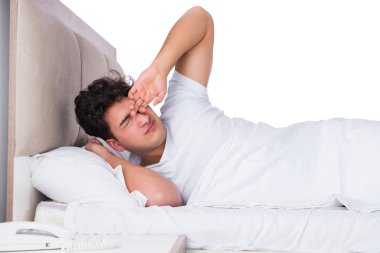 Yatakta uykusuzluk çeken bir adam.