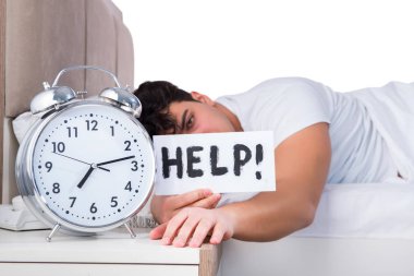 Yatakta uykusuzluk çeken bir adam.