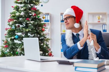 İş adamı Noel tatilini ofiste kutluyor.