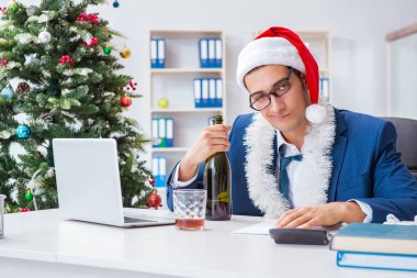 İş adamı Noel tatilini ofiste kutluyor.