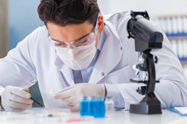 Laboratuvarda virüs aşısı üzerinde çalışan erkek doktor.