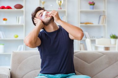 Genç adam estetik cerrahi burnundan sonra evde iyileşiyor.