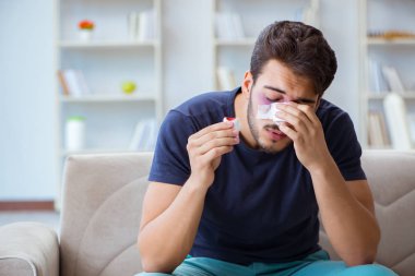 Genç adam estetik cerrahi burnundan sonra evde iyileşiyor.