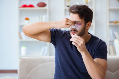 Genç adam estetik cerrahi burnundan sonra evde iyileşiyor.