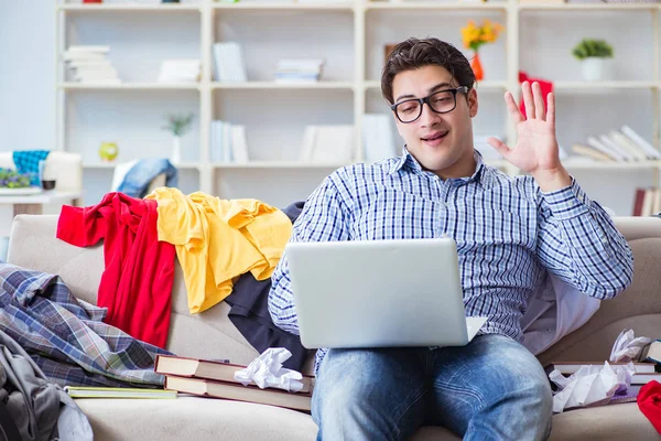 Genç adam dağınık bir odada çalışıyor.