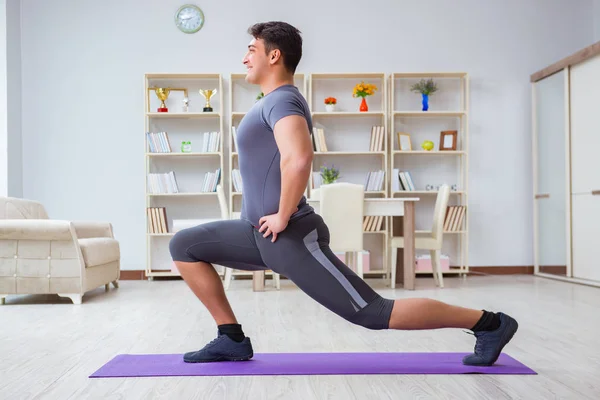 Giovane uomo che esercita a casa in sport e stile di vita sano con — Foto Stock