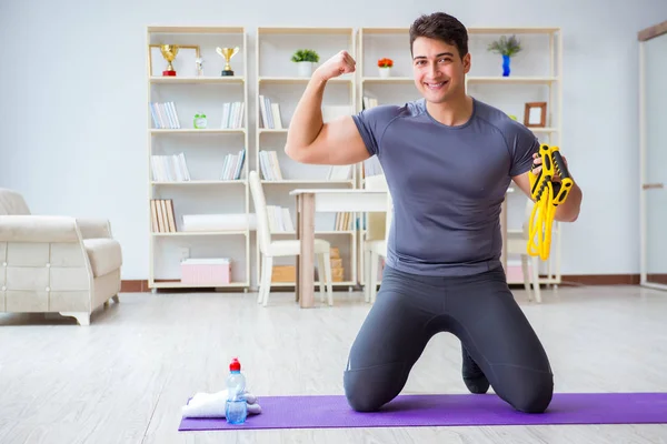 Junger Mann trainiert zu Hause mit Sport und gesundem Lebensstil — Stockfoto